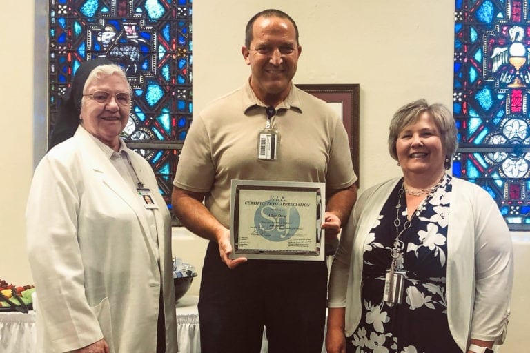 Sister Francesca Lowis, Vice President of Mission Integration, and Brenda Bauer, Vice President of Quality, present Allen Stout with the VIP award.