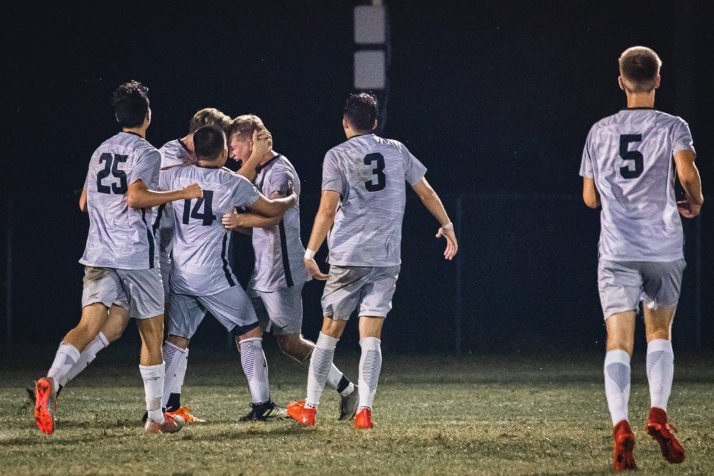 Wesleyan teammates celebrate Josh Tenney's first of two goals Thursday against Urbana.