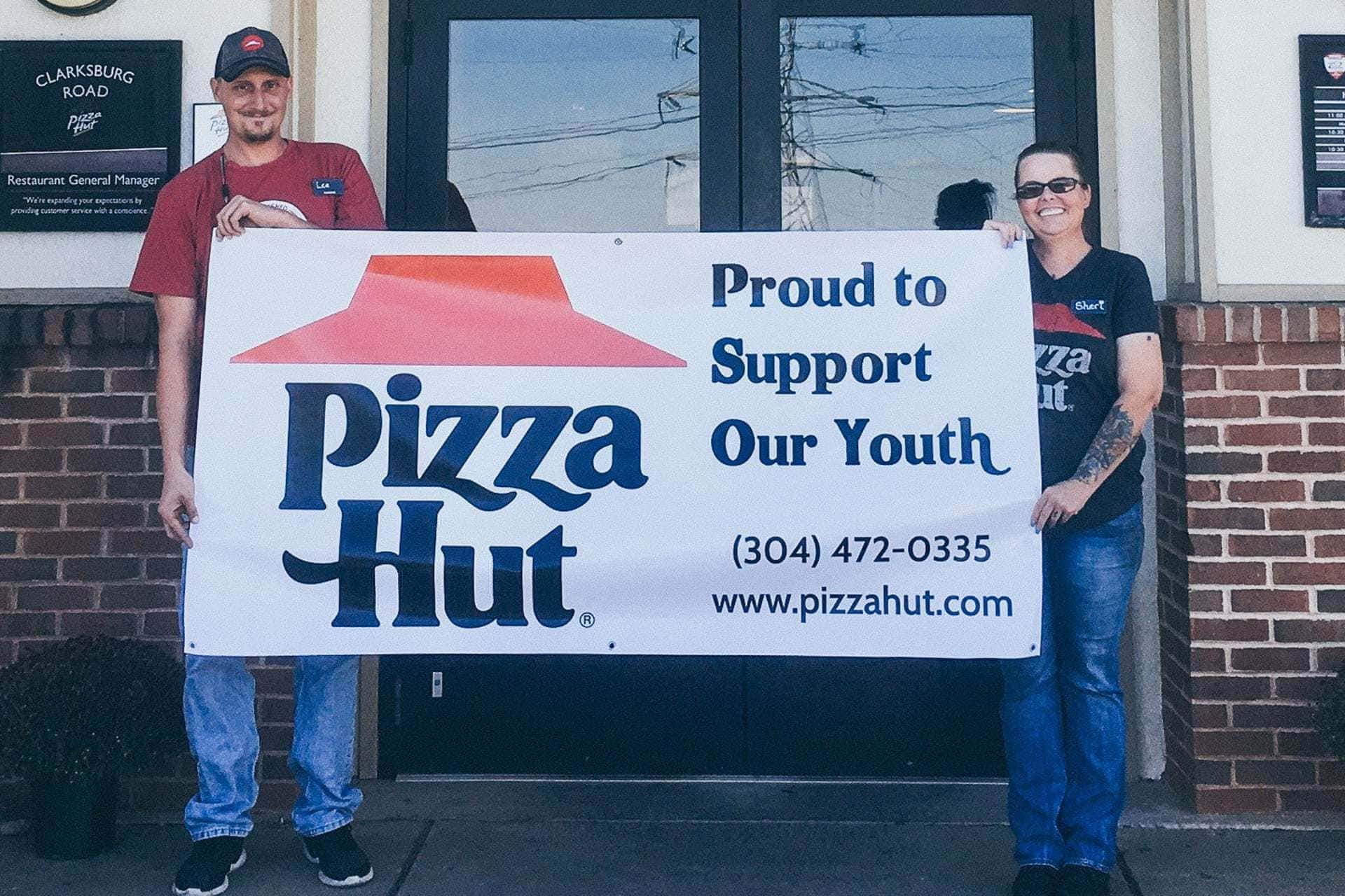 Buckhannon Pizza Hut supports Buckhannon-Upshur High School reading and literacy, as well as other schools, sports teams and clubs in the area. Pictured with their banner are employees Lee Swisher and Sheri Castellani.