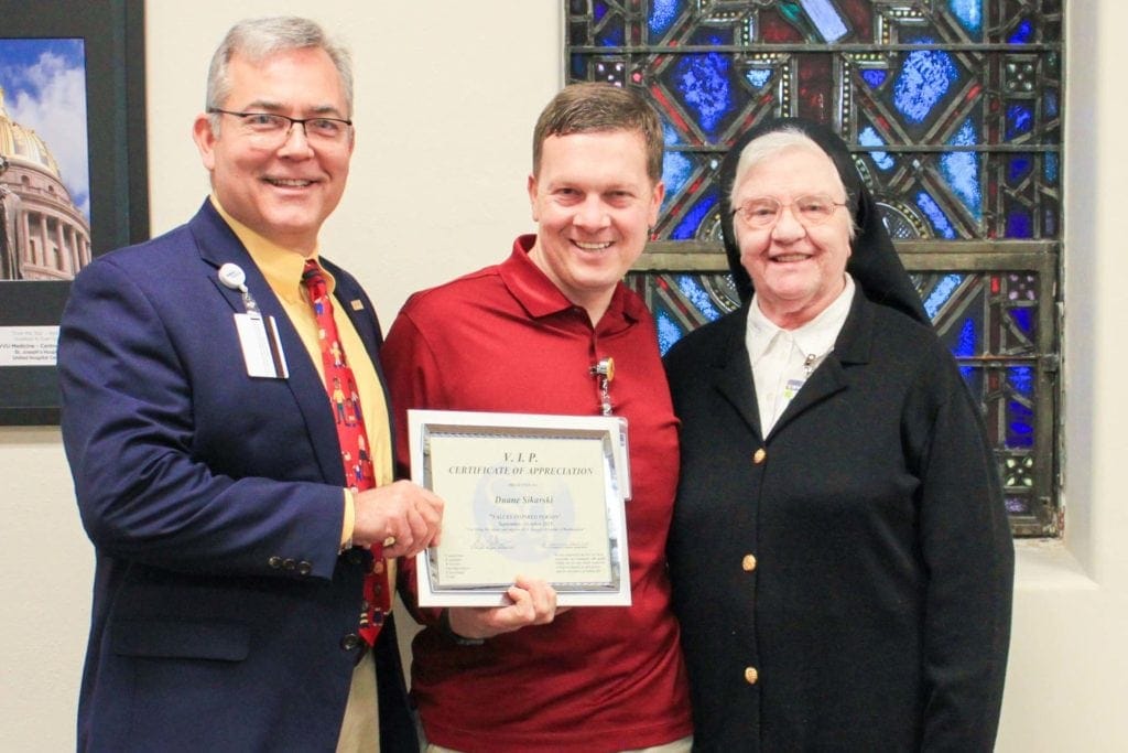 Skip Gjolberg, President, St. Joseph’s Hospital, and Sister Francesca Lowis, Vice President of Mission Integration, present Duane Sikarskie with the VIP award.