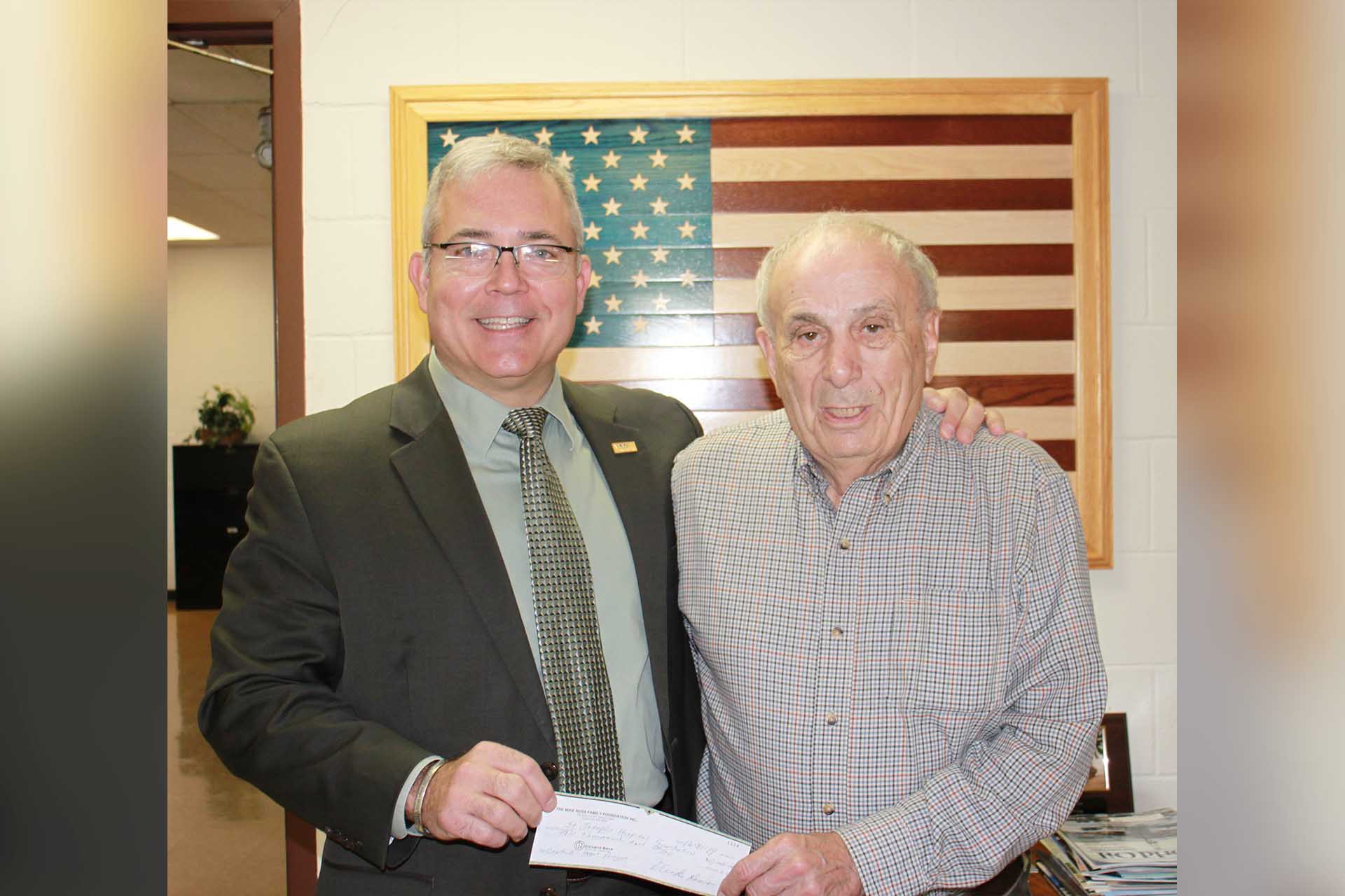 Businessman Mike Ross, right, presents a donation to St. Joseph's Hospital CEO Skip Gjolberg.