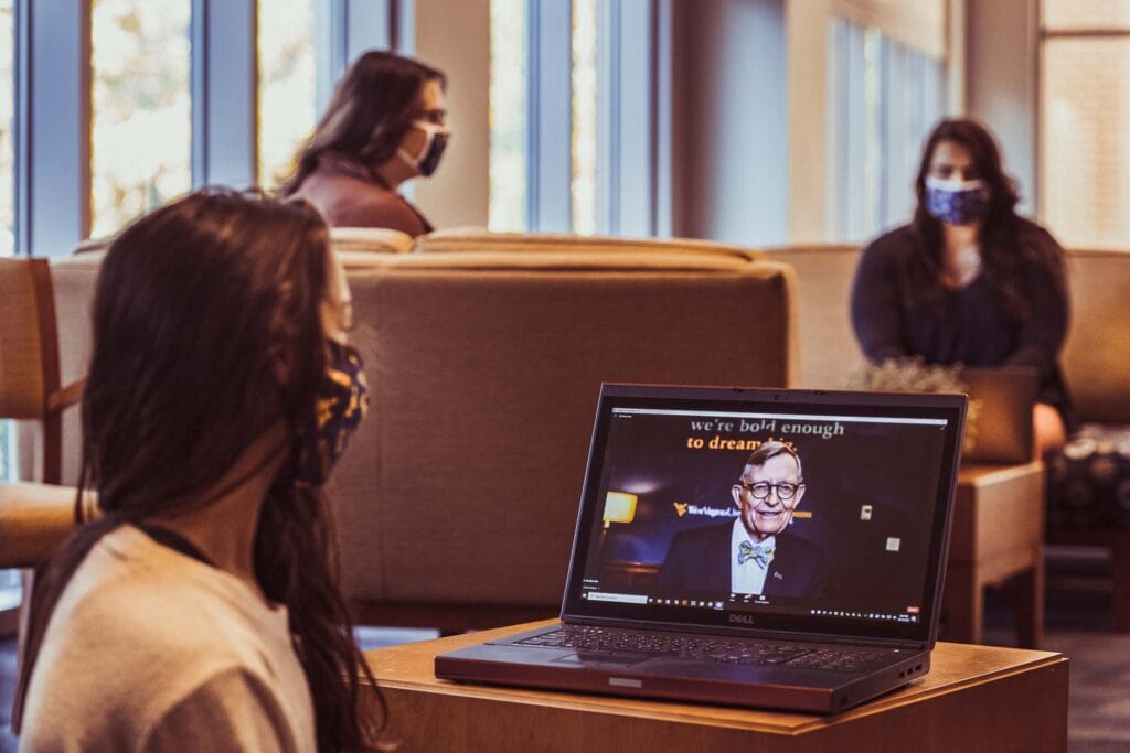 WVU student and visitor center student employ Megan Buchheit and fellow WVU staff Kirsten Swales and Raphy Greco pause their workday to watch the WVU Virtual State of the University during the Covid-19 Pandemic presented by WVU President E Gordon Gee. October 12, 2020. (WVU Photo/Greg Ellis)