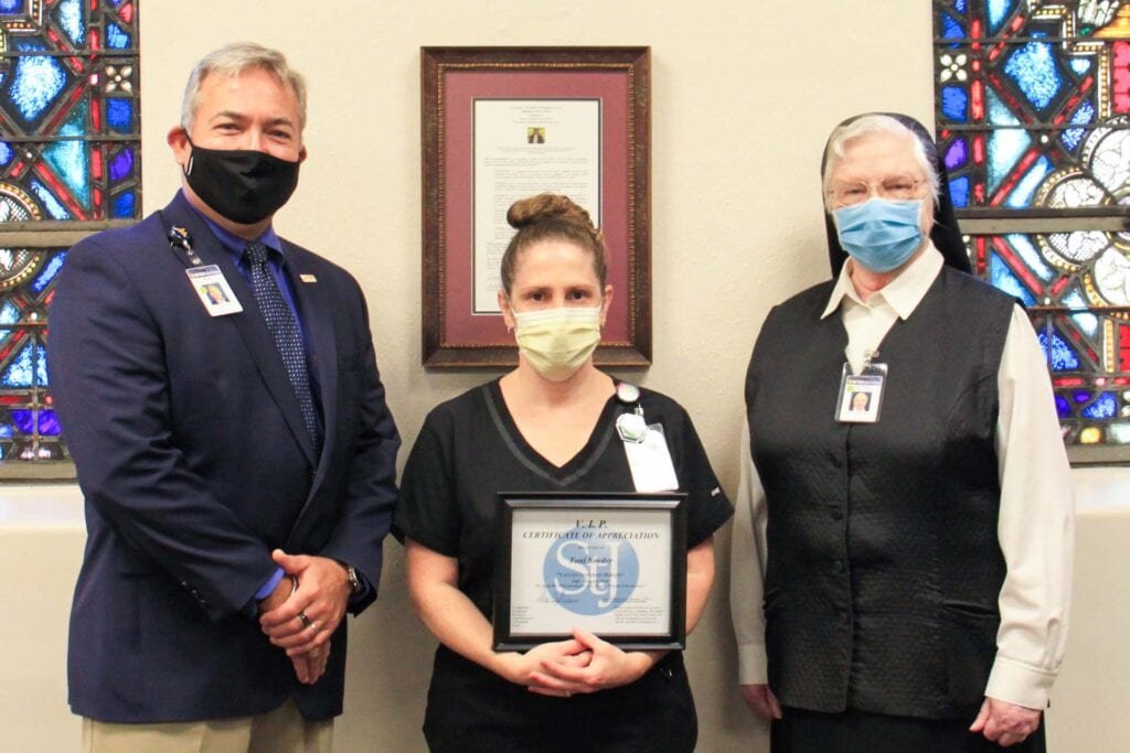 Skip Gjolberg, President of St. Joseph’s Hospital, and Sister Francesca Lowis, Vice President of Mission Integration, present Toni Snyder with the VIP Award.