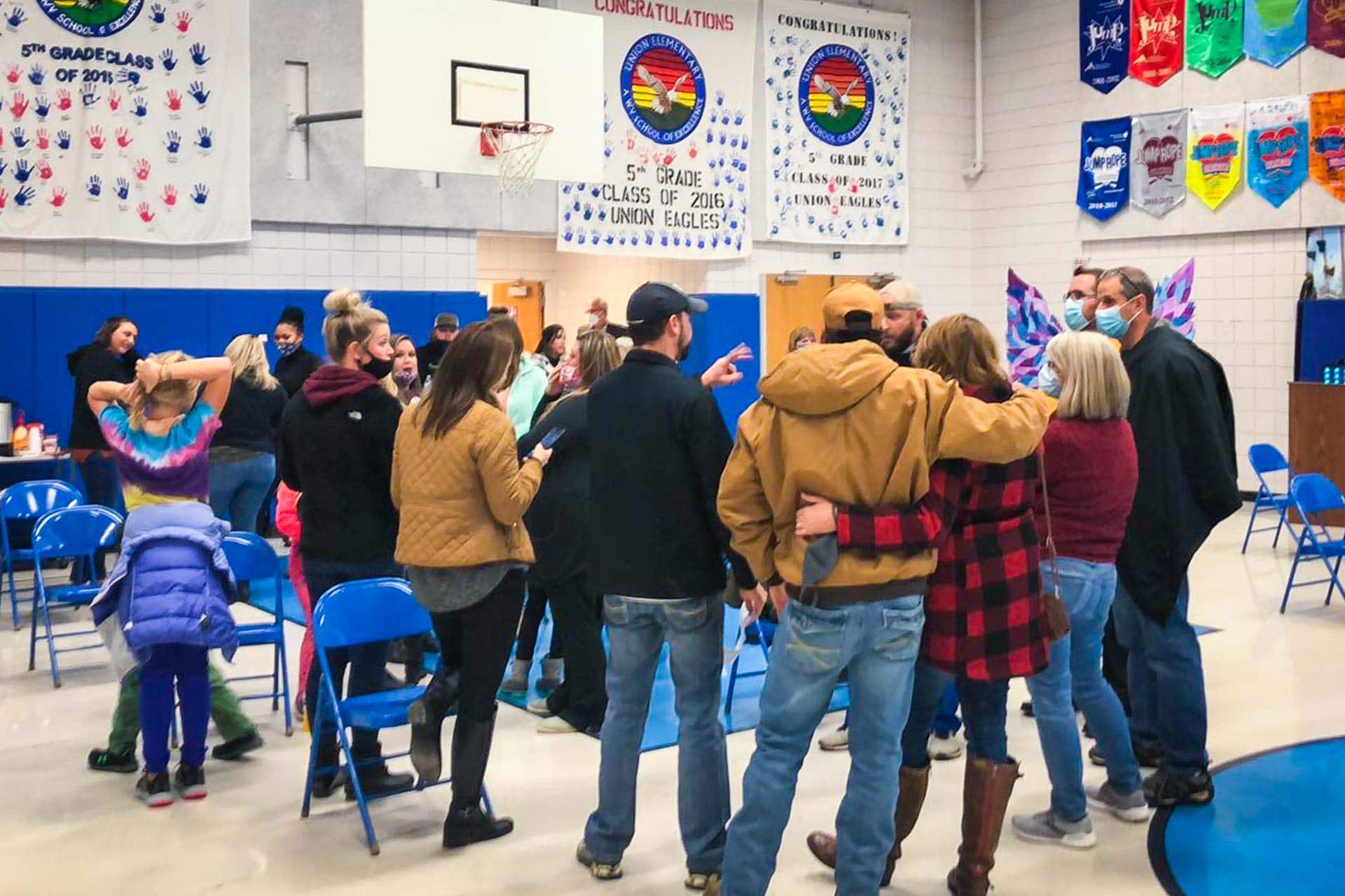 A group of parents and community members gathers in the Union Elementary School gym during a brief suspension of Tuesday's board of education meeting due to repeated audience interruptions.