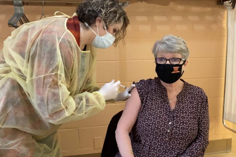 Alisa Lively, Director of Campus Life at WVWC, receives the COVID-19 vaccination from a member of the Wesleyan nursing faculty.