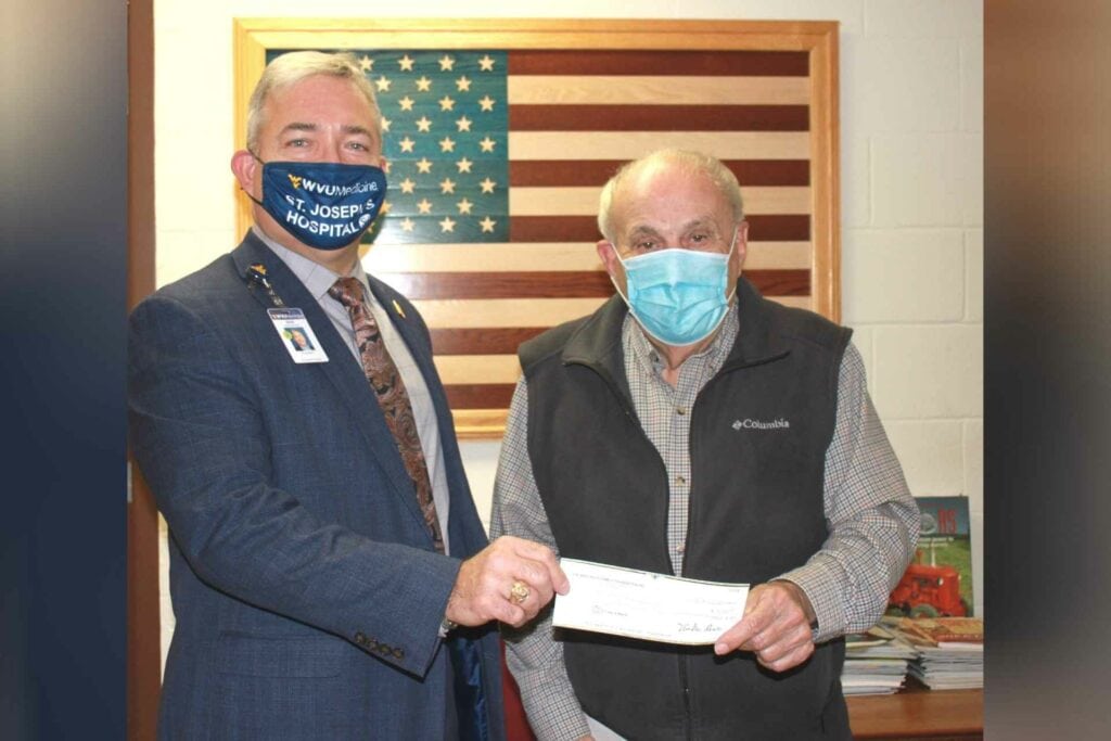 Businessman Mike Ross, right, presents a donation to St. Joseph's Hospital president Skip Gjolberg.