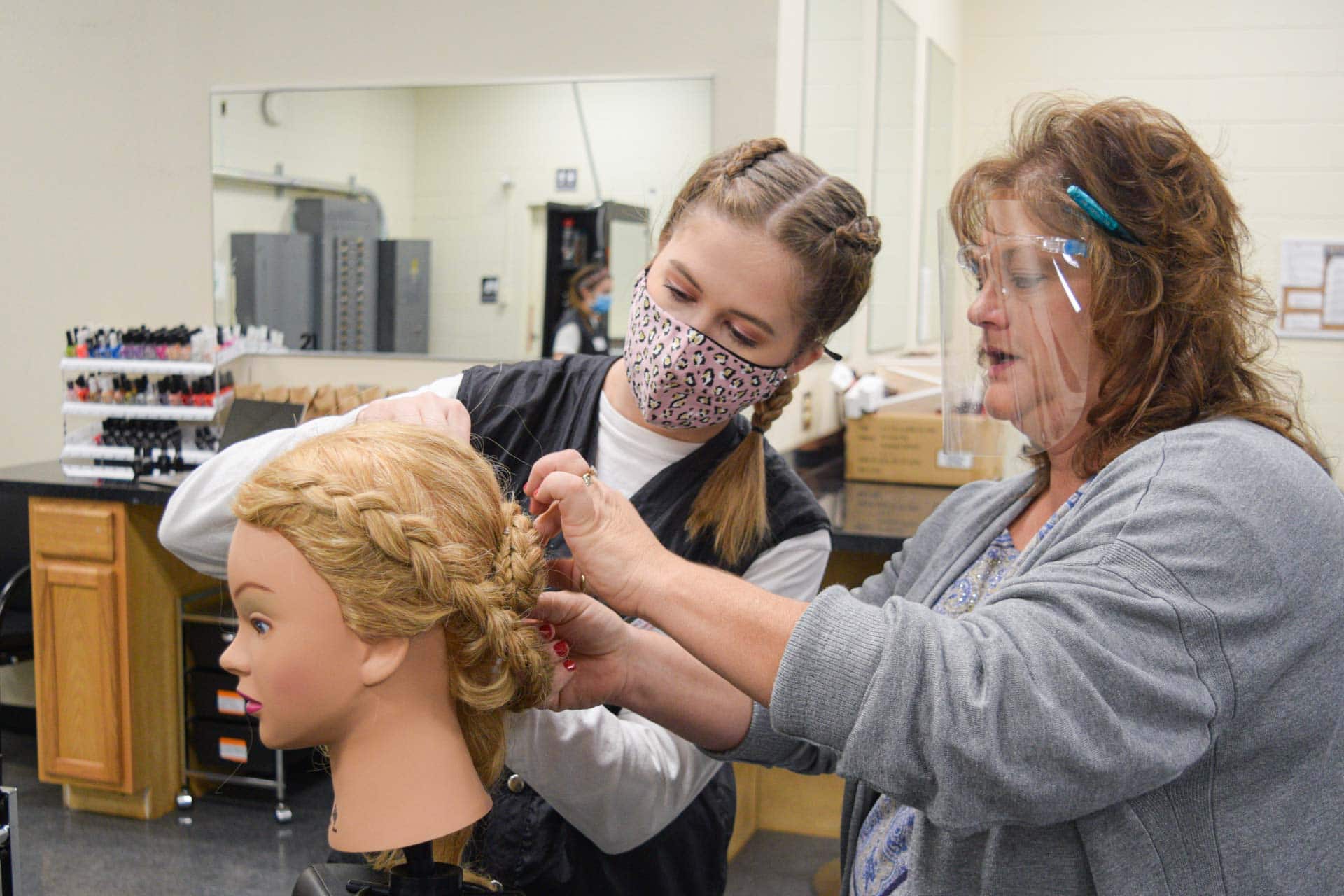 Kaylee Halterman, a cosmetology student at the Fred Eberle Technology Center, works on braiding as instructor Crystal Moss looks on. The cosmetology program at FETC is currently taking applications for the next class, which begins around August and takes approximately 14 months to complete.