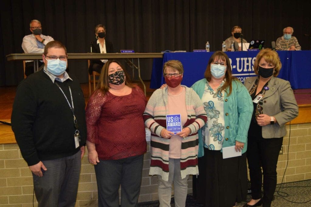 Secretaries at Buckhannon Academy Elementary School receive Upshur Stars for being the backbone of the school. Principal Susanne Britton and Assistant Principal Eric Brand, along with Upshur County Superintendent of Schools Dr. Sara Lewis Stankus, recognize Tera Spotloe and Sheila Davis during Tuesday’s Upshur County Board of Education meeting.