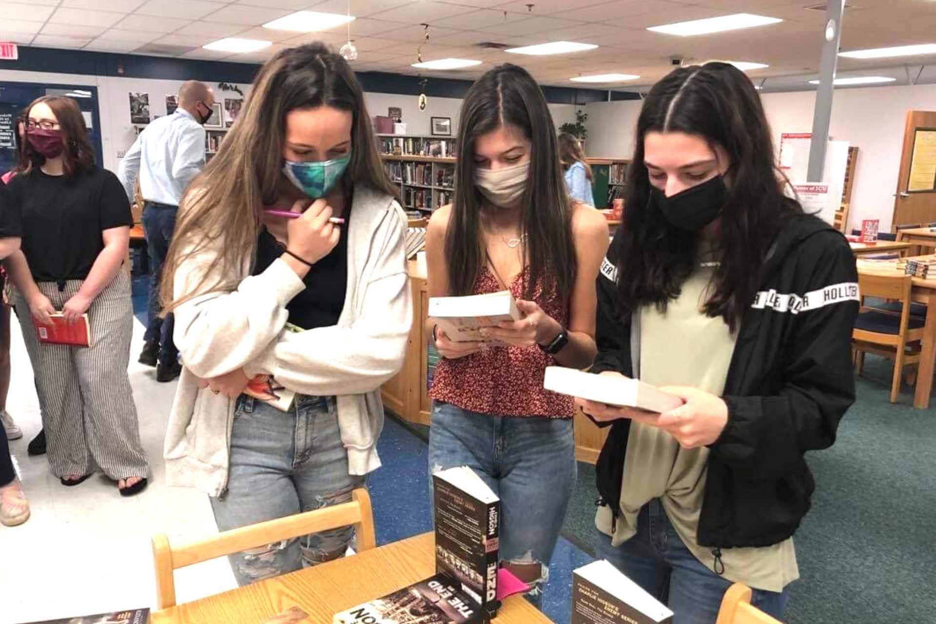 Buckhannon-Upshur High School students Kloey Chapman, Bella Weatherholtz and Olivia McKisic browse books donated by West Virginia Read Aloud during a recent event at the school celebrating School Library Week. More than 1,000 books were donated to the school so students could select the perfect book to help rekindle the love of reading.