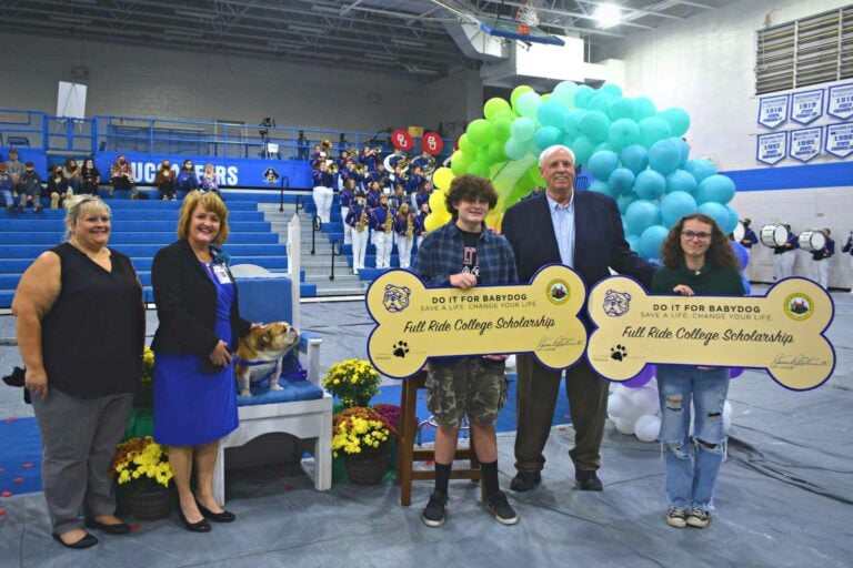 Governor Jim Justice presents scholarships to two Buckhannon-Upshur High School students selected as winners in the Do It For Babydog vaccine lottery, sophomore Benjamin Currence and senior Lillian Keith. Also pictured are Upshur County Board of Education President Dr. Tammy Samples and Superintendent of Schools Dr. Sara Lewis Stankus.