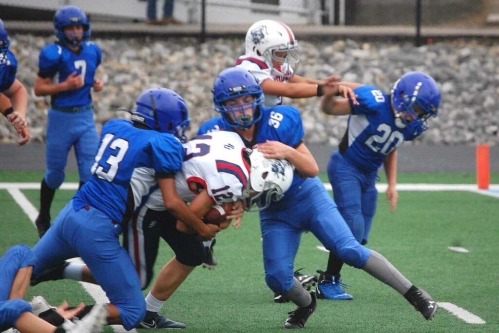 Dawson Tenney of the Buckhannon-Upshur Middle School Little Bucs plows ahead as two Barbour County defenders attempt to bring him down. (Duane Carpenter photo)