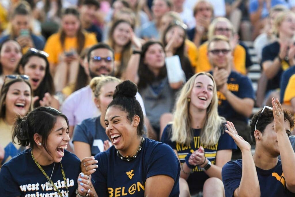 Students laugh as they enjoy the 2021 Monday Night Lights event at Milan Puskar Stadium. The Class of 2025 Welcome Week event was held Sunday, Aug. 22, after it was postponed because of weather the previous week. (WVU Photo/Jennifer Shephard)