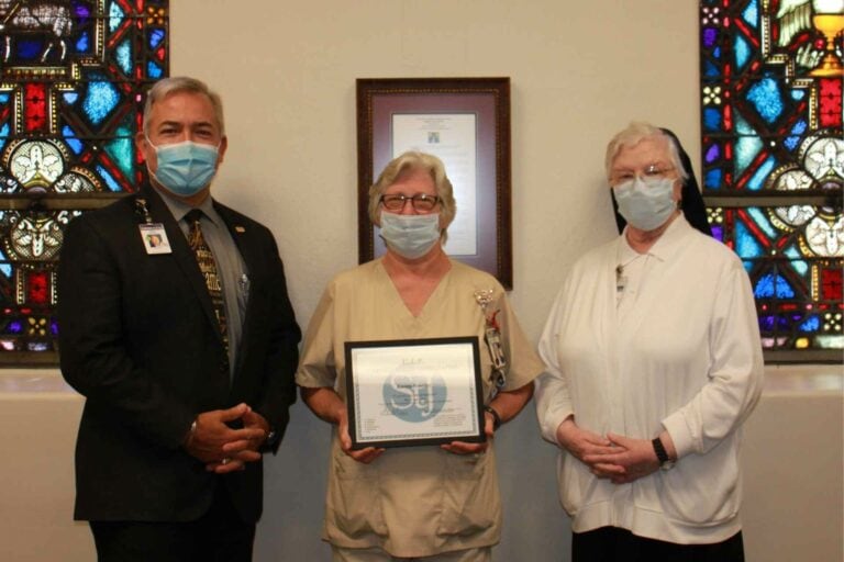 Skip Gjolberg, President of St. Joseph’s Hospital and Sister Francesca Lowis, Vice President of Mission Integration present Karen Woofter with the VIP award.