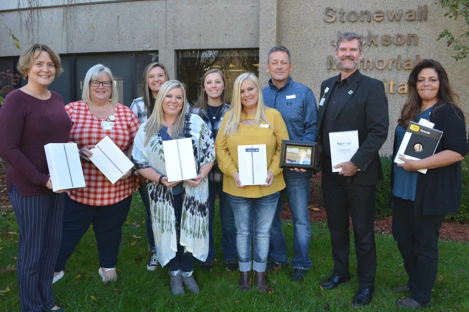 The family of the late Hunter Osborn donated iPads to Mon Health Stonewall Jackson Memorial Hospital for use by patients in his memory. Pictured above are family members and Mon Health staff receiving the iPads. Pictured front row L-R: sister Erica Weaver, mother Cindy Osborn; second row, L-R: SJMH staff member Jennifer Barnes, staff member Carla Hamner, Hunter’s girlfriend Tera Stout, sister Kayla Talbert, father Darin Osborn, SJMH CAO Kevin Stalnaker, and staff member Maria Maul.
