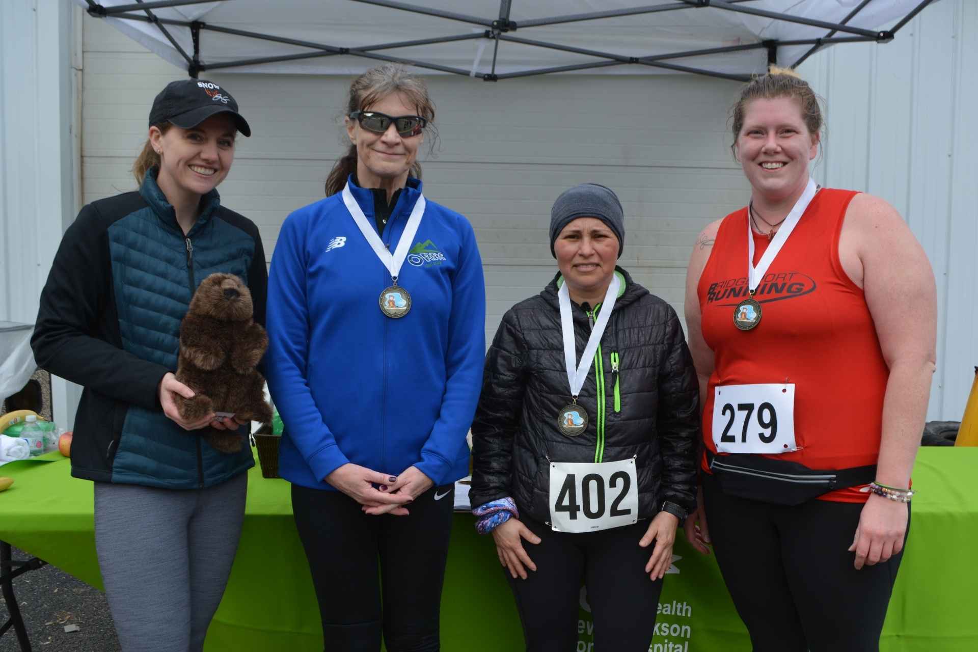 The top three female racers at the recent Mon Health Stonewall Jackson Memorial Hospital 5K were awarded medals by Physical Therapy intern Katie Ruhstaller. Pictured left to right are: Ruhstaller, first place winner Lyn Miksell, second place Yamileth Setterlund, and third place Tasha Coulthart.