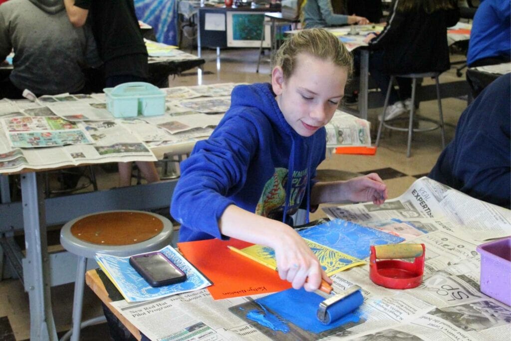 Kaitlyn Nicholson uses blue paint on one of her prints.