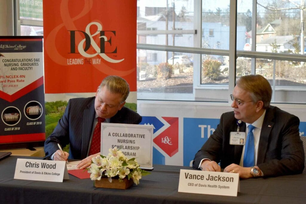 Davis & Elkins College President Chris A. Wood, left, and Davis Health System President and CEO Vance Jackson sign an agreement for the Davis Medical Center Healthcare Scholarship. D&E students seeking their Associate in Science degree in nursing will have an opportunity to apply for the scholarship.