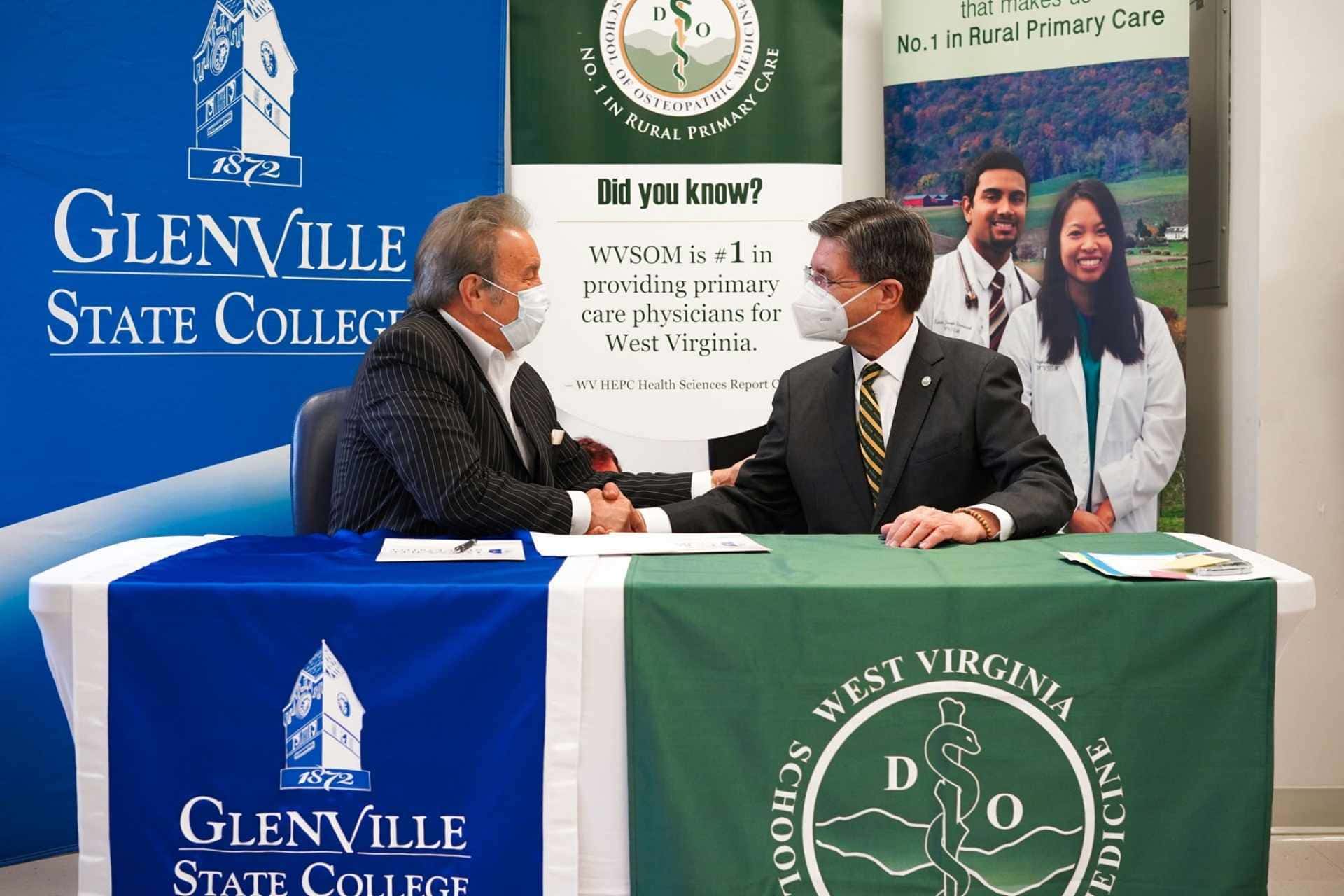 Glenville State University President Dr. Mark A. Manchin (left) and West Virginia School of Osteopathic Medicine President James W. Nemitz, Ph.D. shake hands following a recent signing ceremony welcoming Glenville State into the WVSOM Pre-Osteopathic Medicine Program.