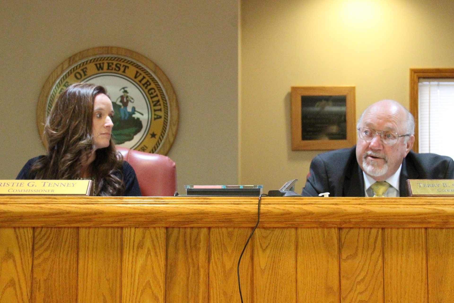 Upshur County Commission president Kristie Tenney listens as commissioner Terry Cutright praises outgoing administrator Carrie Wallace and welcomes her replacement, Tabatha Perry.
