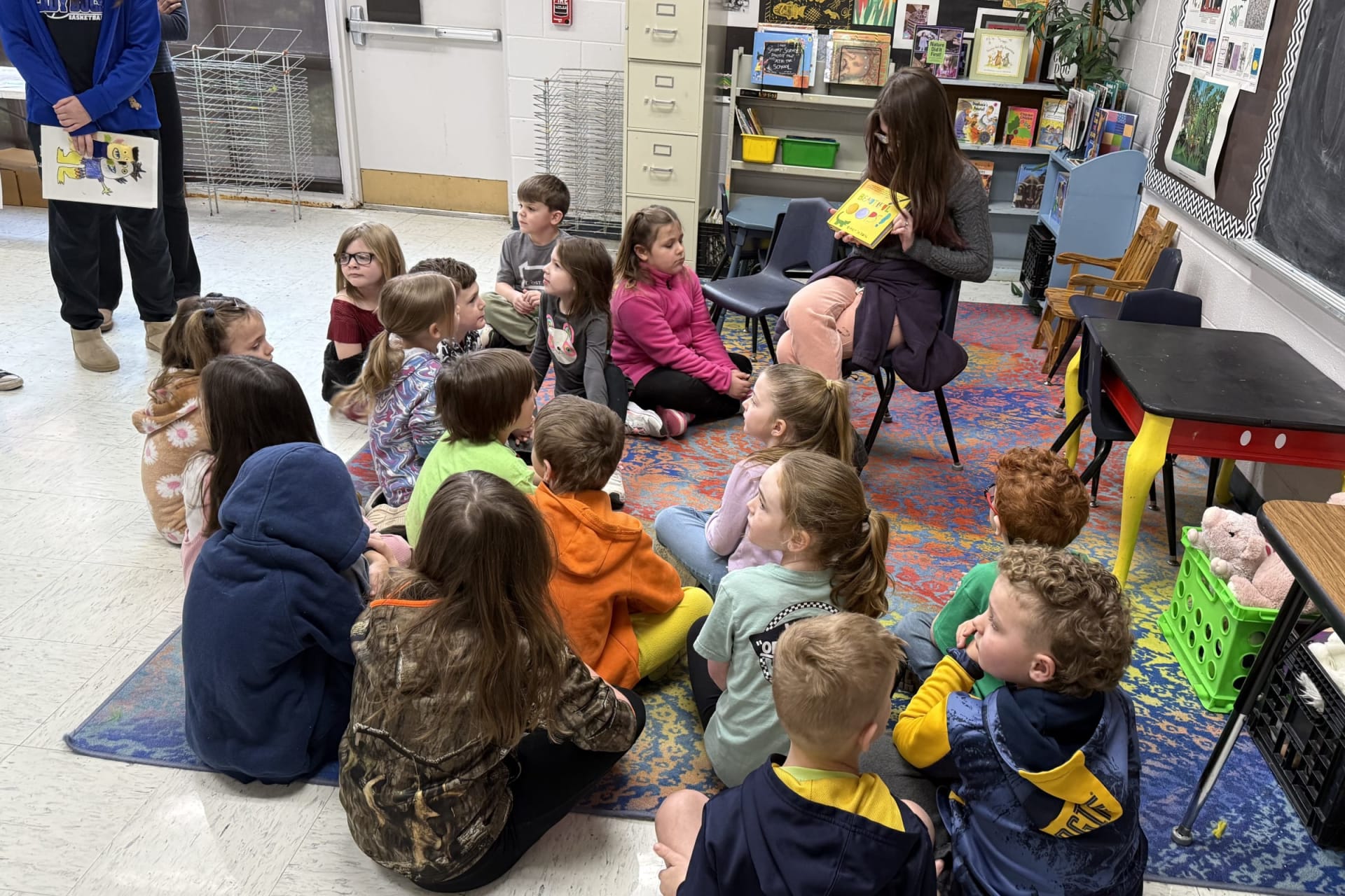 A B-UHS high school student reads to Buckhannon Academy first graders during the classroom visit