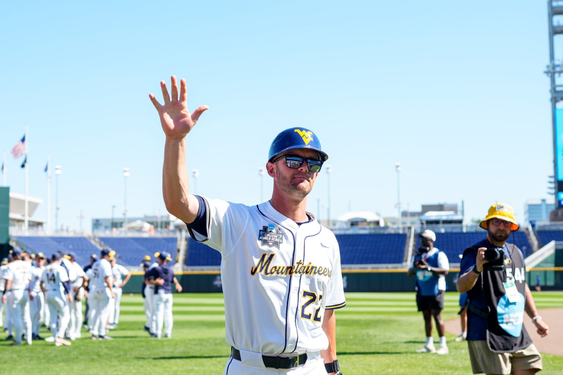 A WVU Mountaineers player in a number 22 jersey waves to fans at the College World Series in Omaha