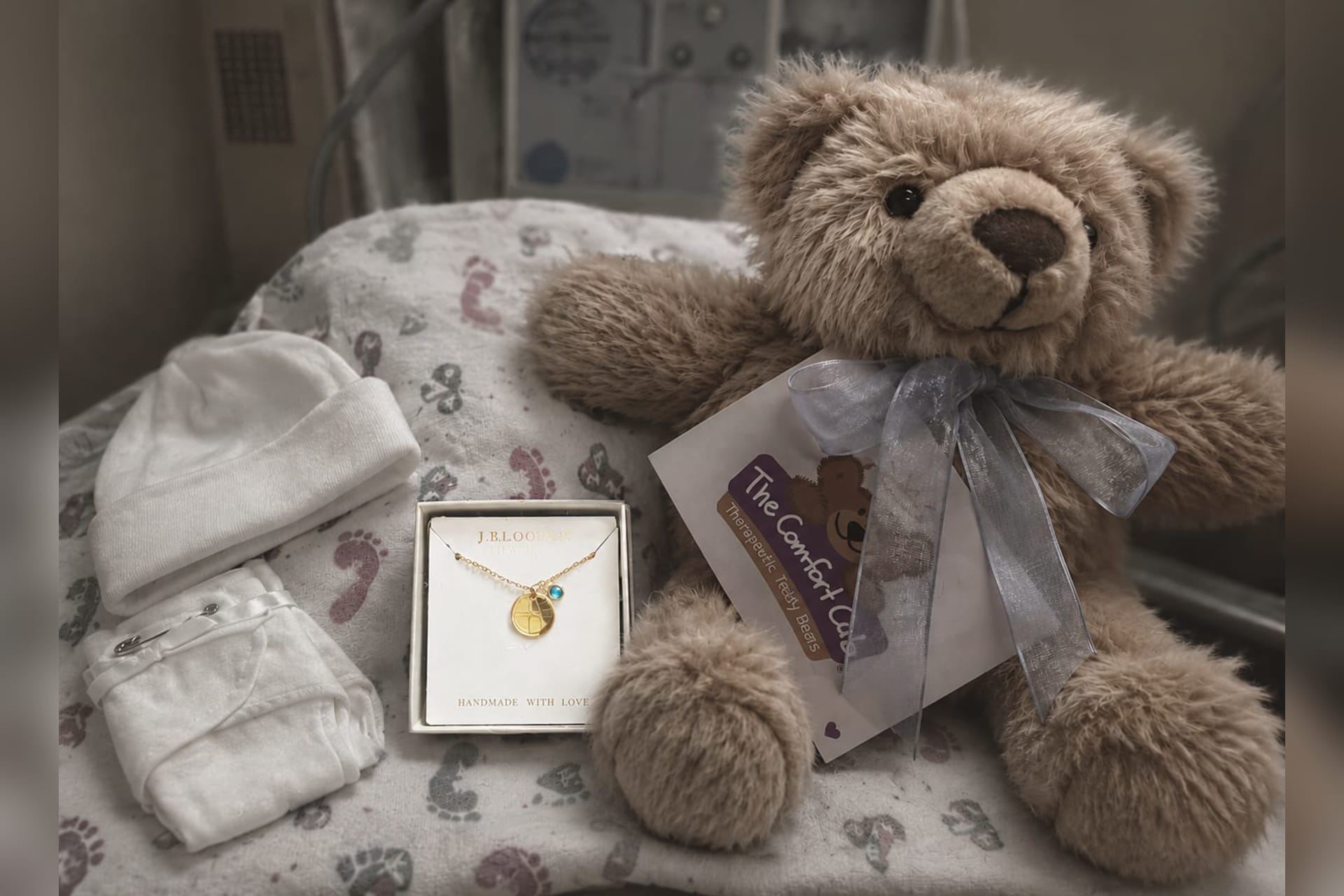 A teddy bear, baby clothing and a memorial necklace are included among comfort items for families experiencing pregnancy loss.