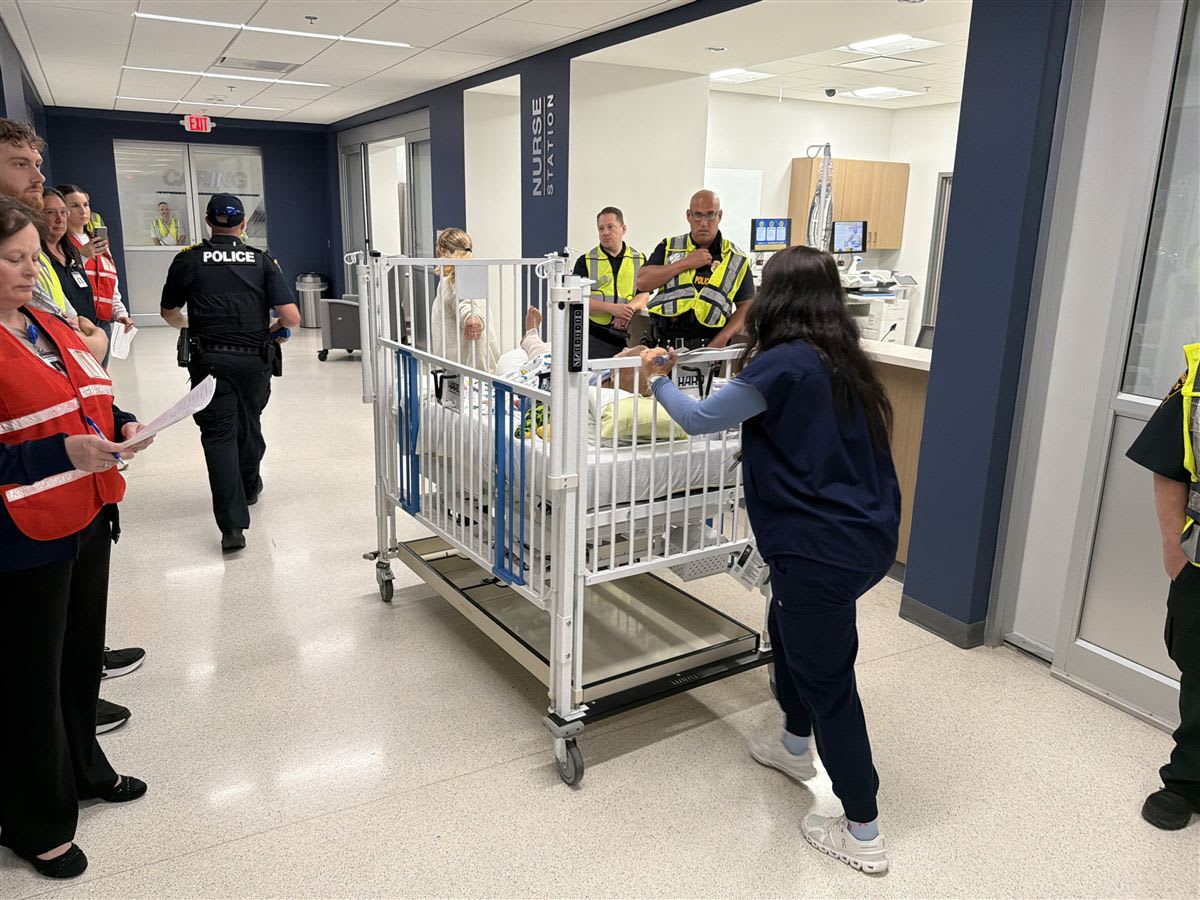 Clinical professionals move a simulated patient during an emergency preparedness exercise at the WVU Medicine Center for Nursing Education.