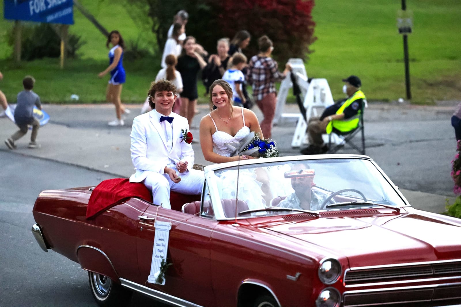 Two homecoming court members ride in a red convertible during the B-UHS parade.